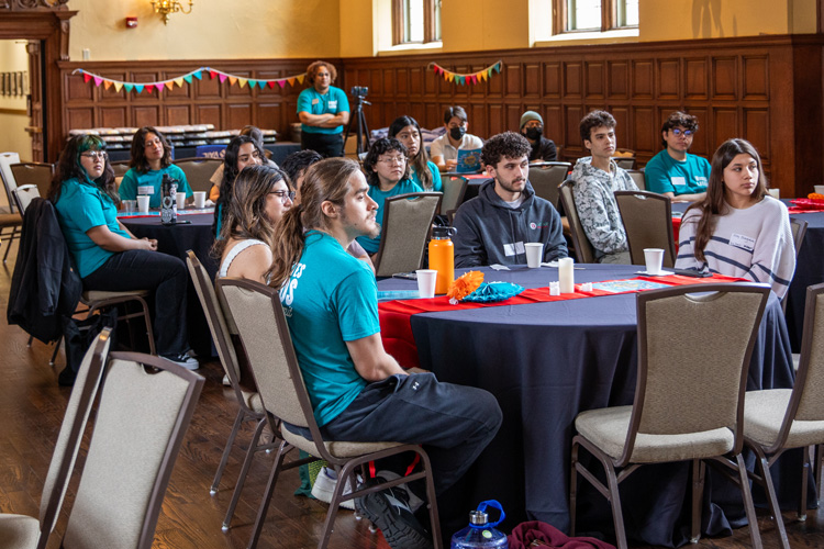 students sitting at tables at an event